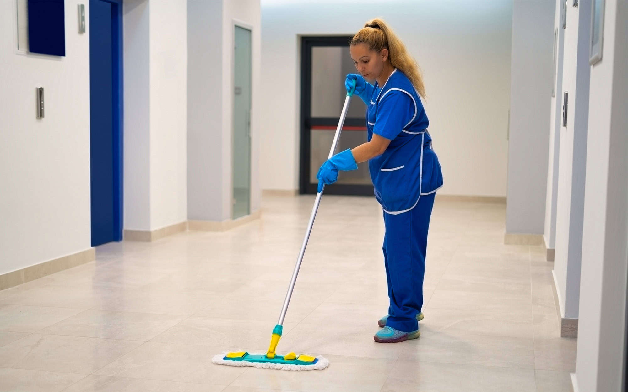 A cleaning lady mops the floor in an office building A Cleaning Lady Mops The Floor In An Office Building
