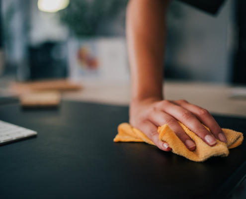 Close Up Image Of A Female Person Cleaning Black Desk In Modern Office